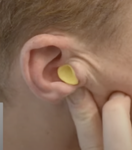 How do I place the earplugs in my ears?